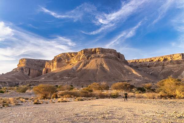 Man looking up at the hill in the Yemen Desert-1 by...