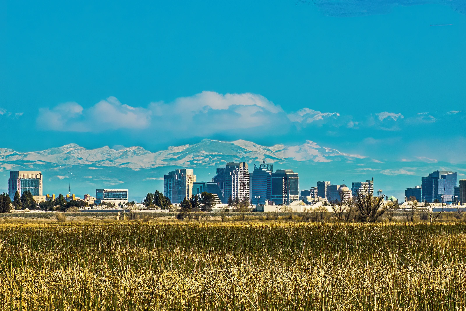 Clouds, mountains, city, fields. State capitol skyline from Yolo Bypass