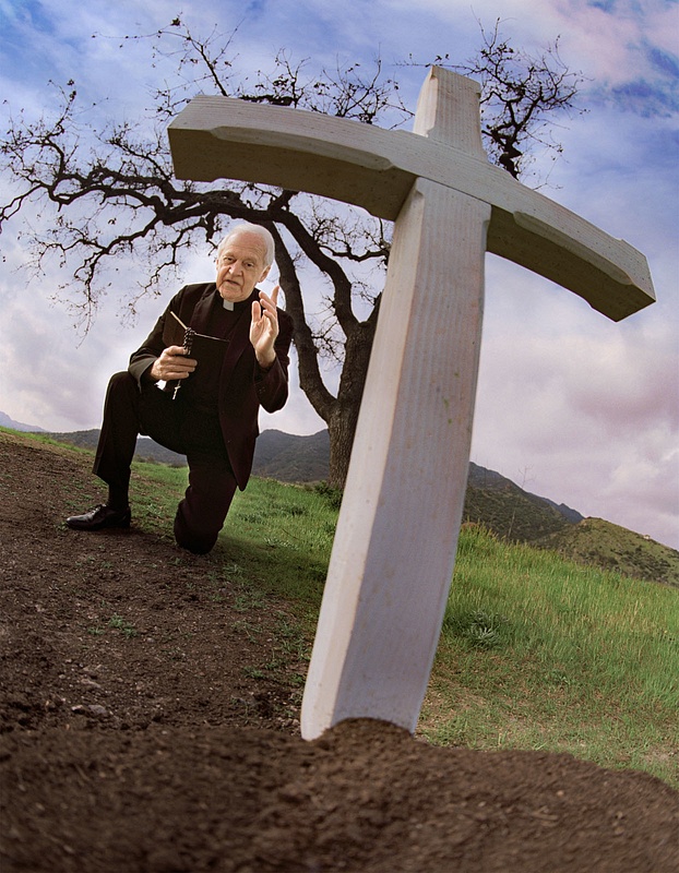 Priest_Kneeling next to Cross-